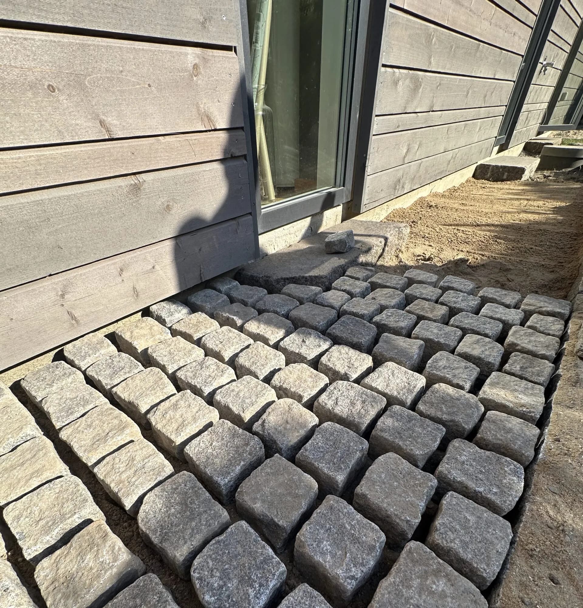 Granitbrosten - Granitbrosten ved indgangspartiet giver et klassisk og slidstærkt udtryk. Lagt med fald mod bed for afvanding.